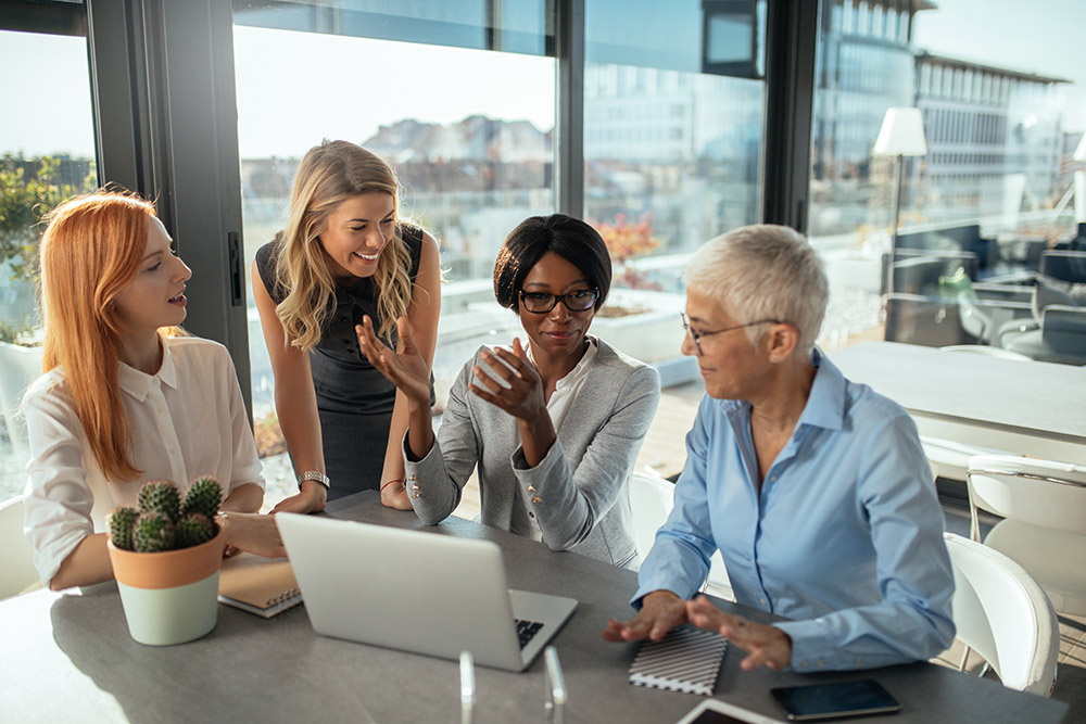 women networking around a computer