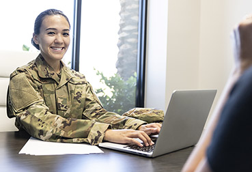 A female Air Force Military member in the office with a computer